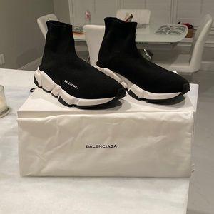 Balenciaga sock sneaker in black sock with white trim and black bottom soles.